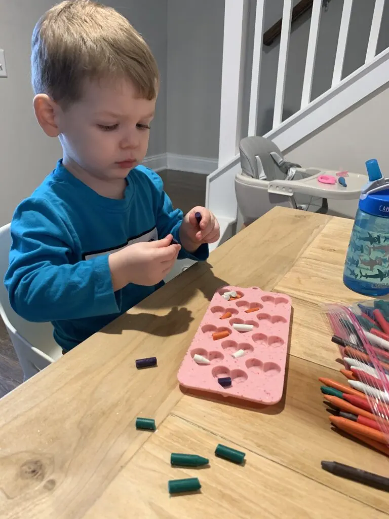 toddler breaking crayons for mold