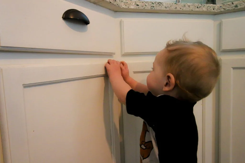 baby trying to unlock cabinet