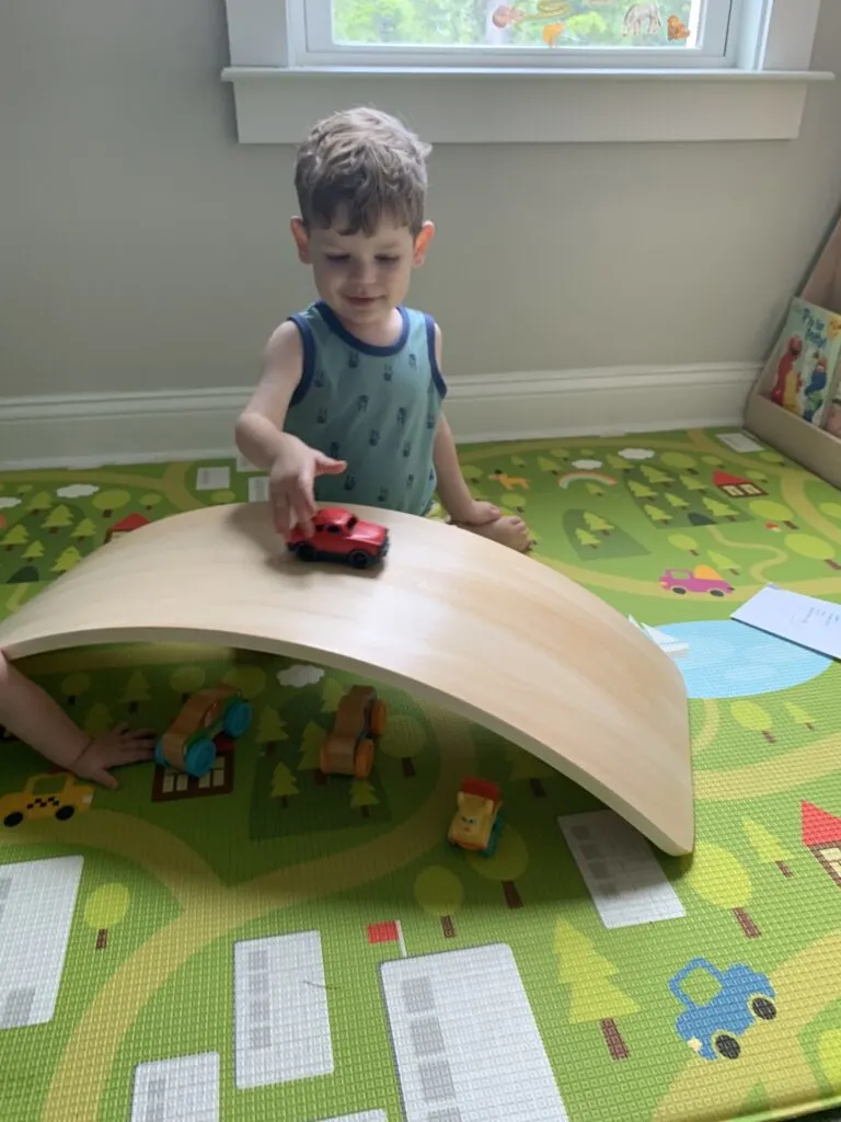 using a wobble board as a bridge or ramp with toy cars