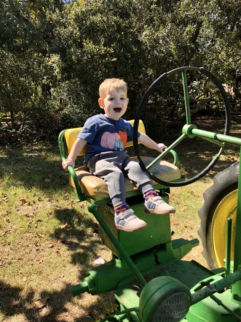 toddler on tractor at pumpkin patch