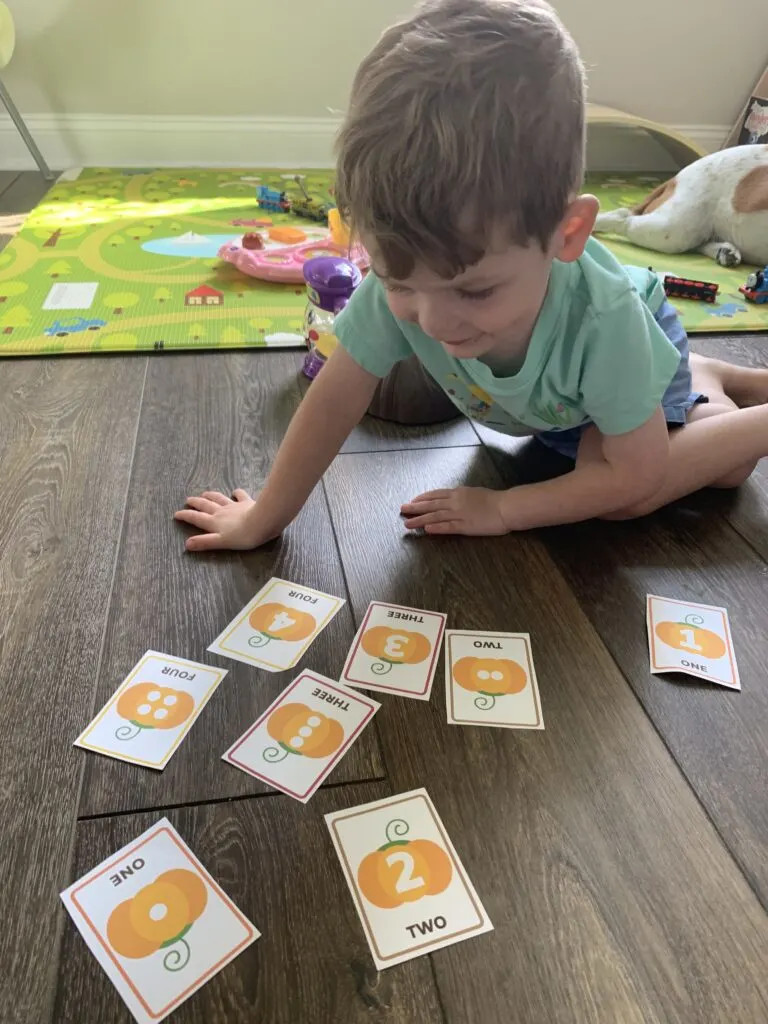 toddler playing with Fall memory matching game - free printable!