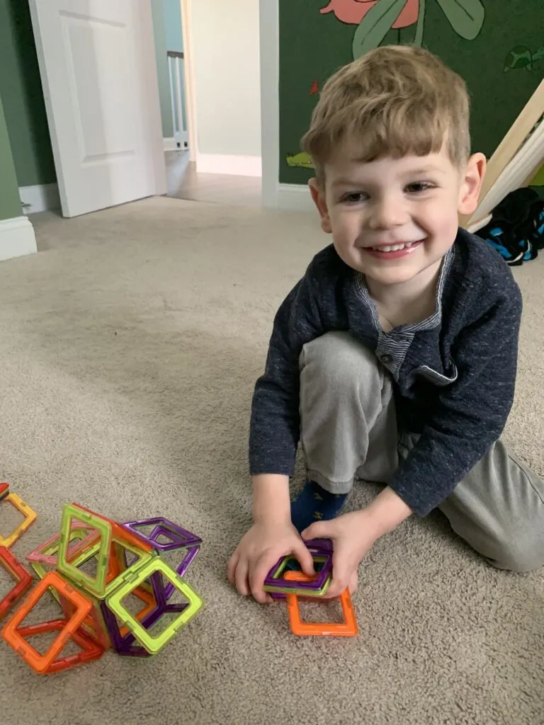 toddler playing with magnetic tiles