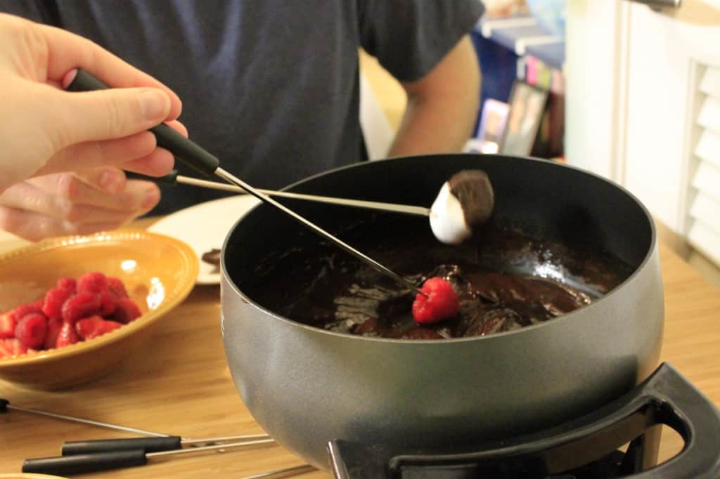 marshmallow being dipped into chocolate fondue