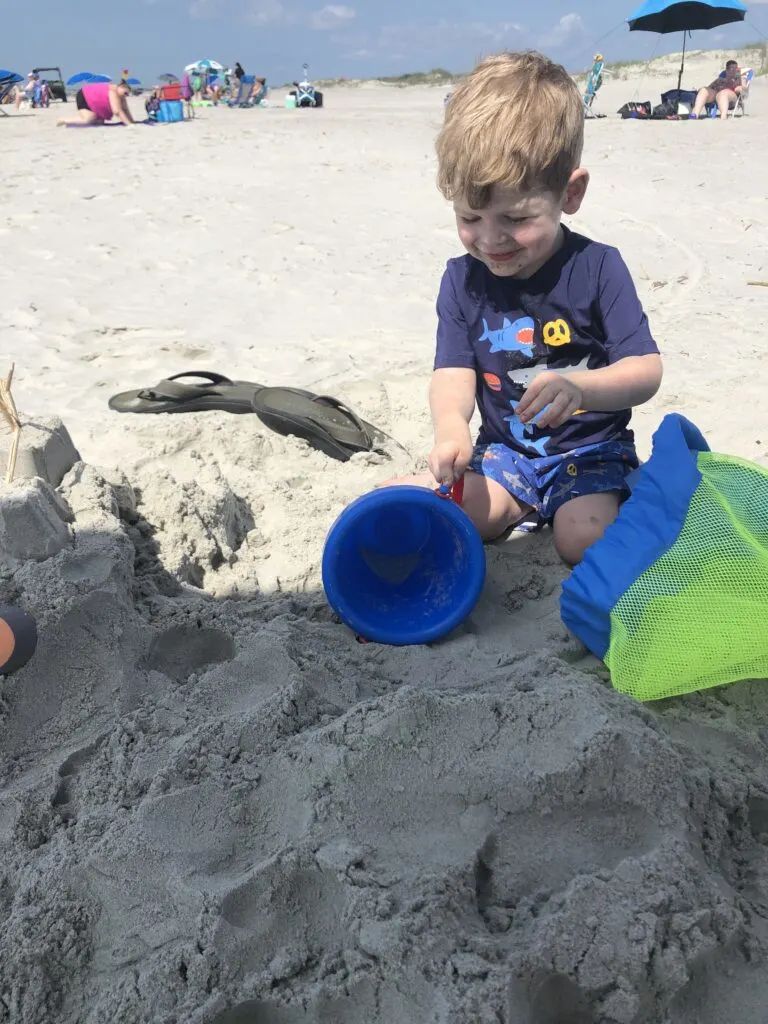 toddler playing with beach toys