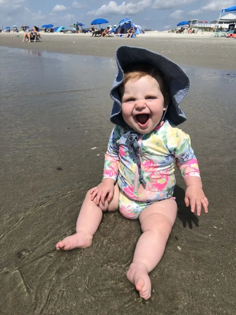 baby laughing on the beach