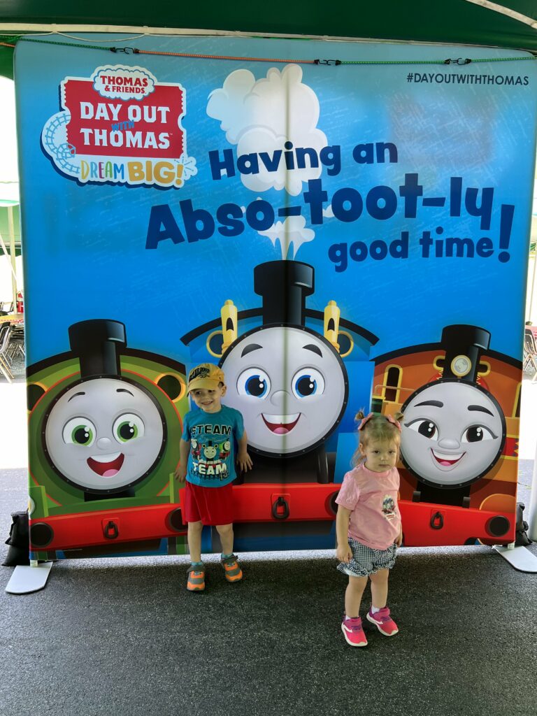 kids posing with thomas the train poster