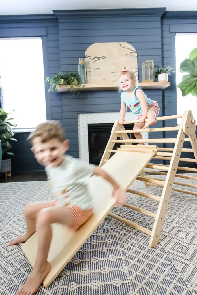 two kids playing on a piccalio pikler triangle