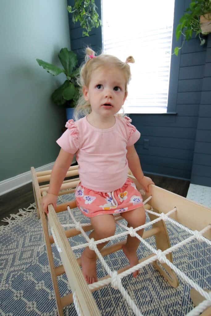 toddler sitting on climbing net