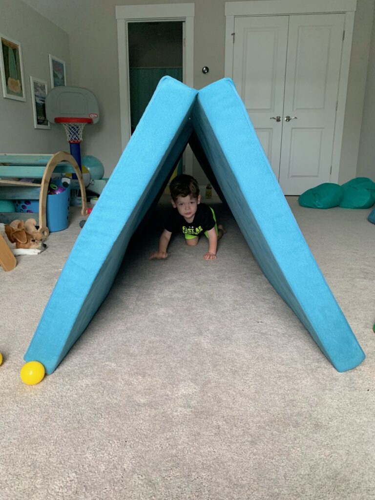 toddler climbing through a nugget tunnel