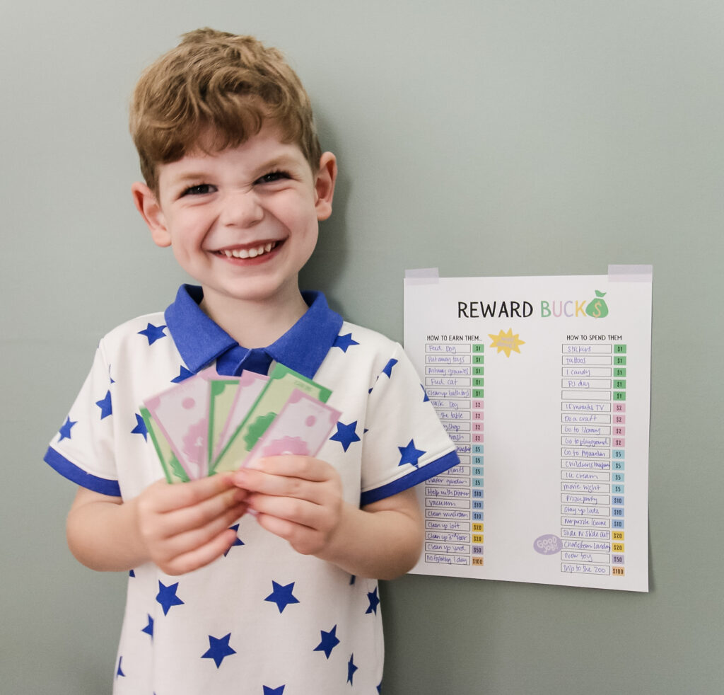 boy with printed reward chart and reward bucks from the Little Celebrators Club