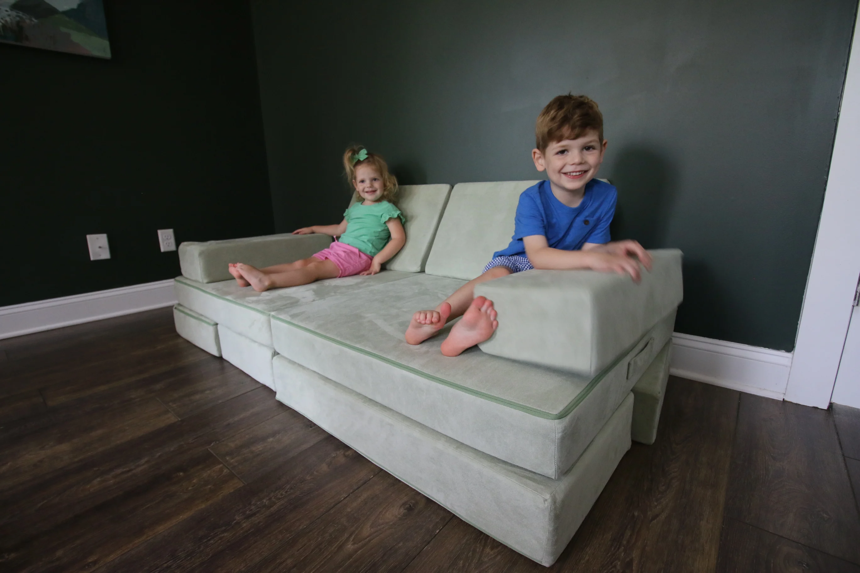 2 kids sitting on a barumba play couch