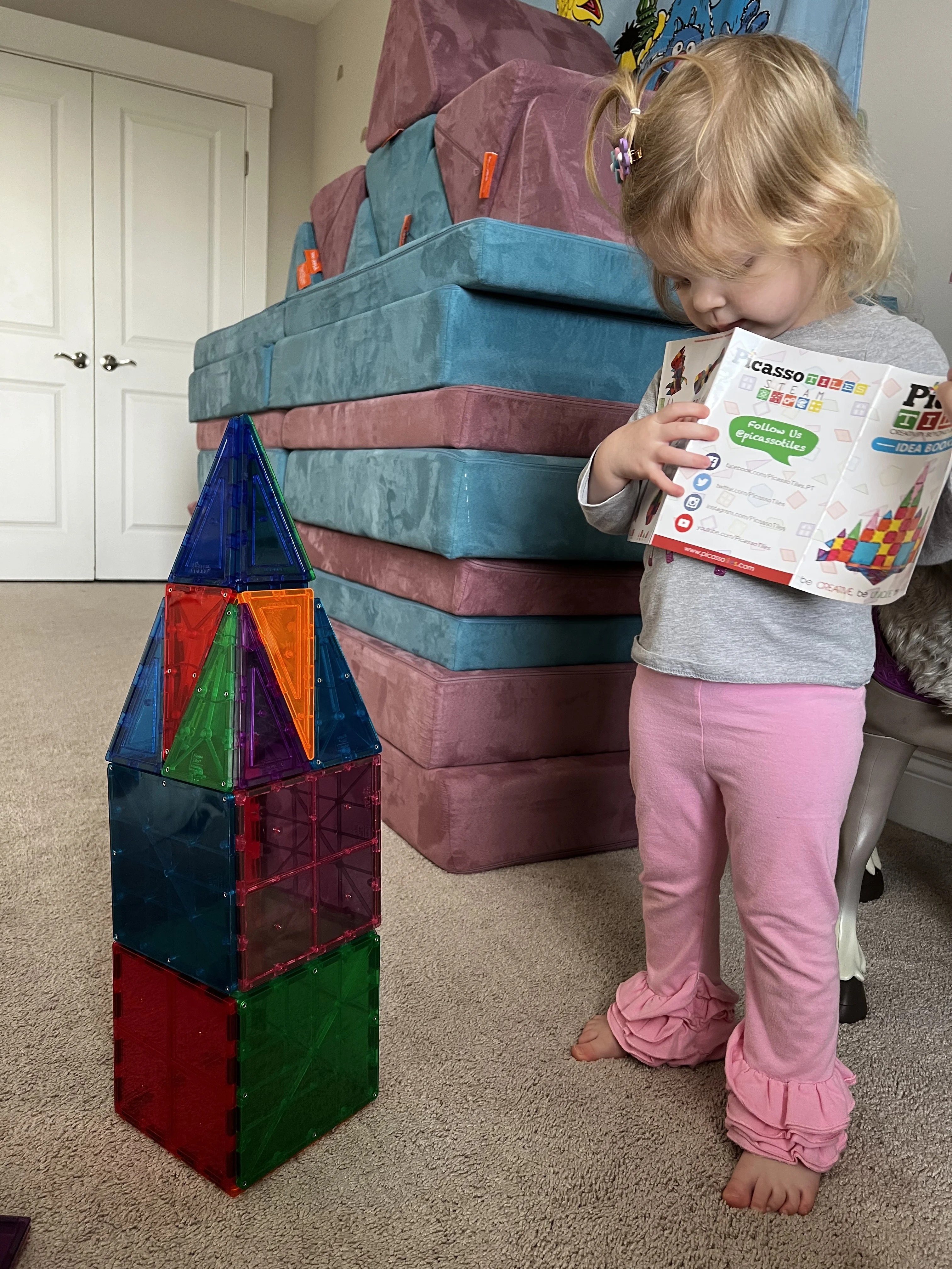 2 year old girl with a magnetic tile tower