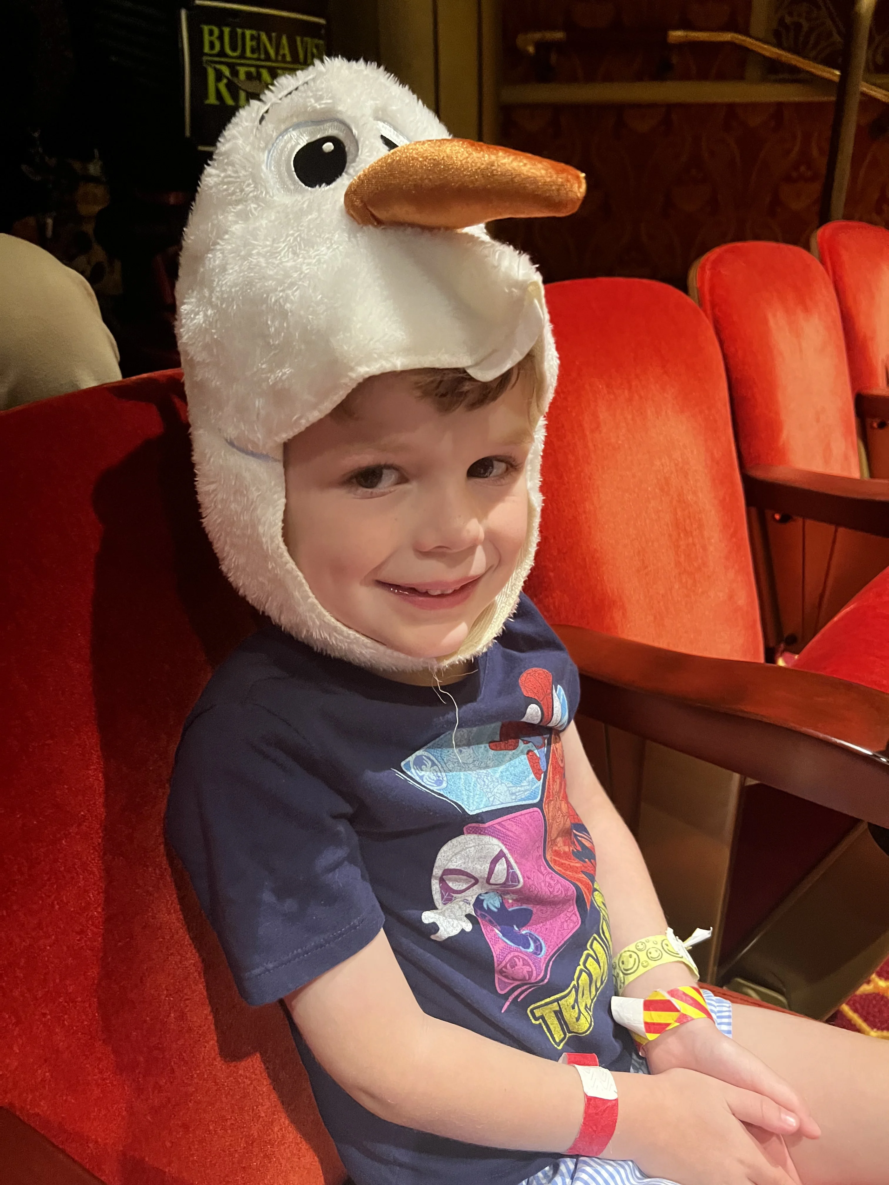 kid in an olaf hat on a disney cruise