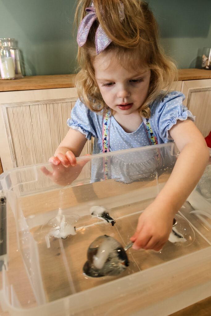 playing with frozen penguins ice sensory bin