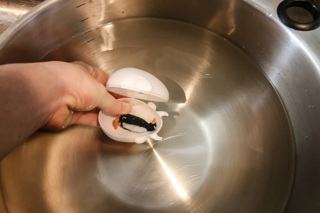 filling a plastic egg with water with a toy inside it