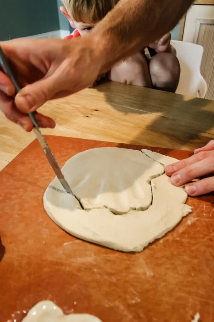 cutting out a clay handprint