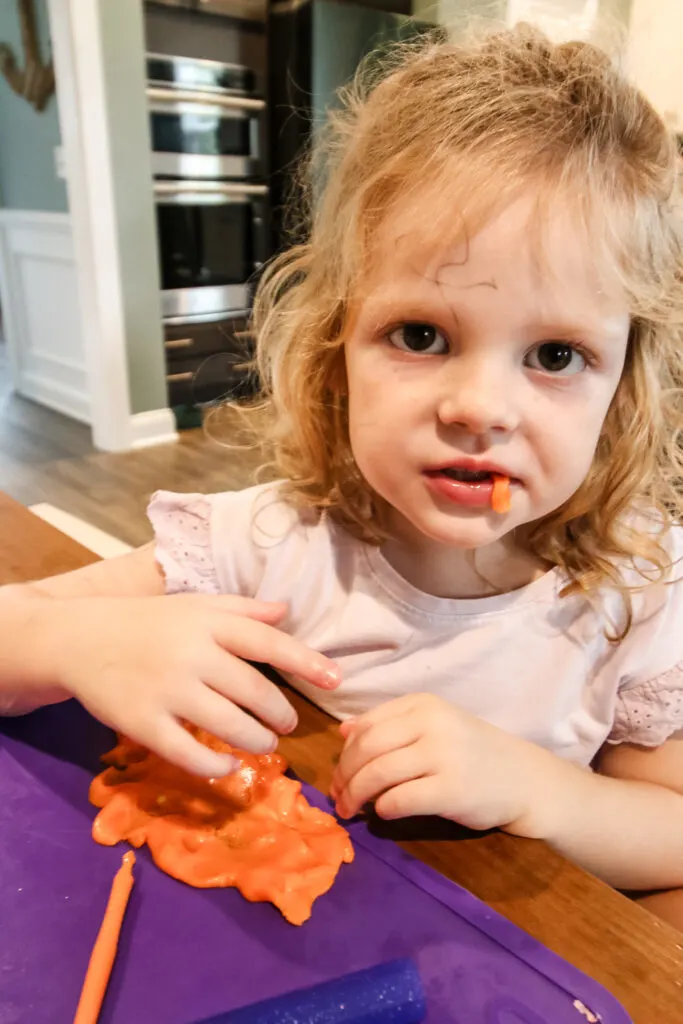 girl eating candy corn play dough