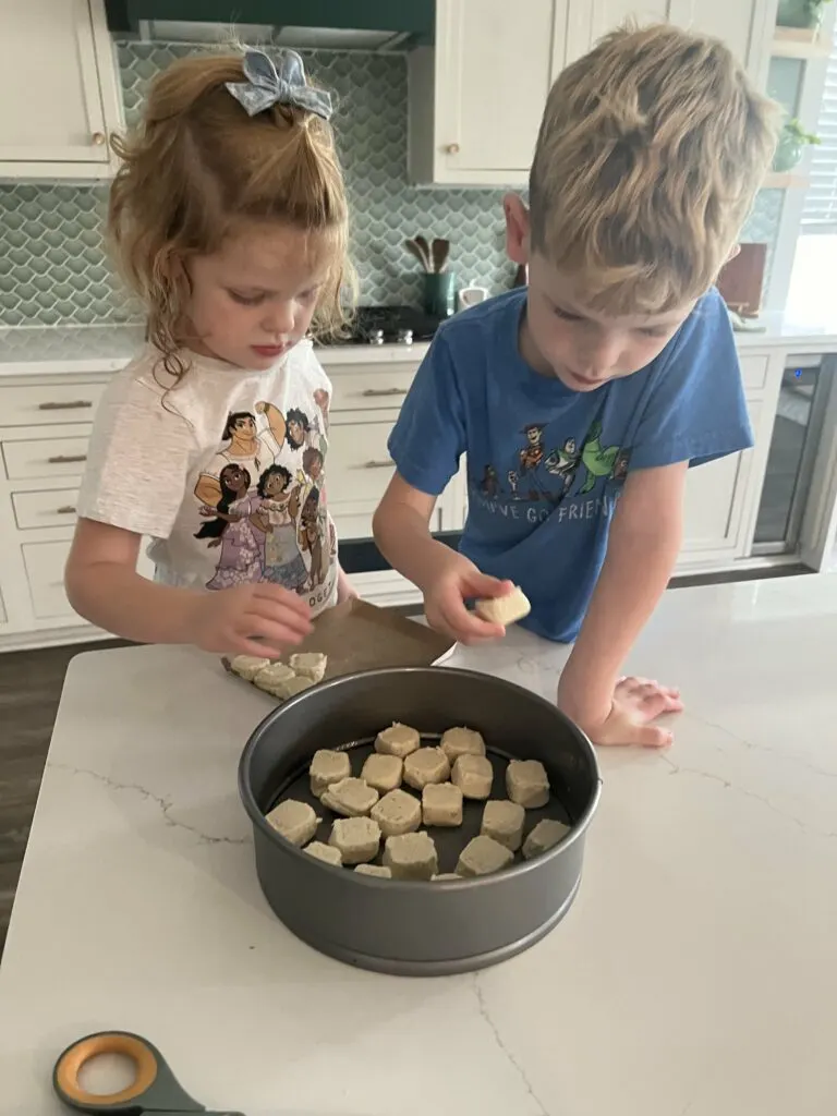 pressing sugar cookie dough to make a cookie cake