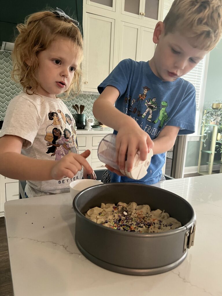 adding sprinkles to a halloween cookie cake