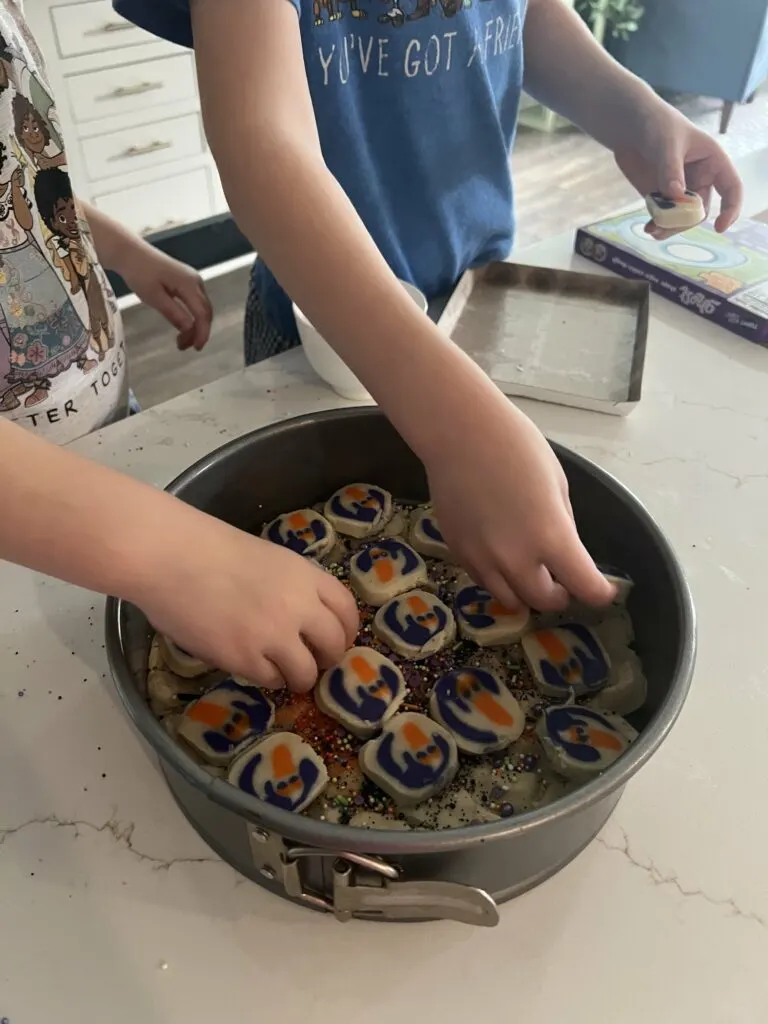 adding halloween cookies to a cookie cake