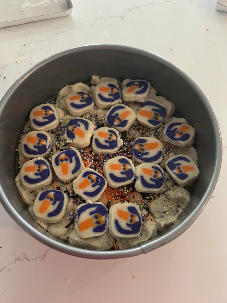 adding halloween cookies to a cookie cake