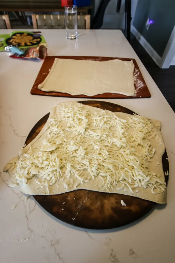 spreading cheese on pizza dough