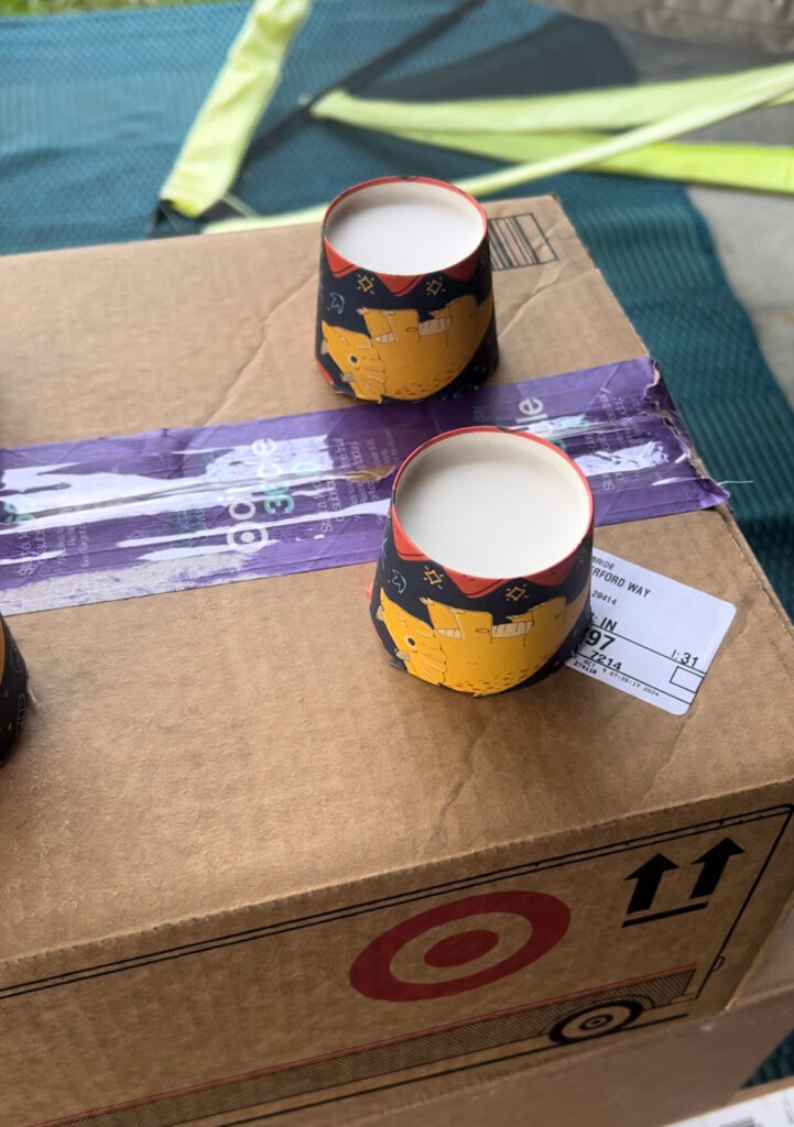 gluing paper cups onto boxes to make cardboard lego