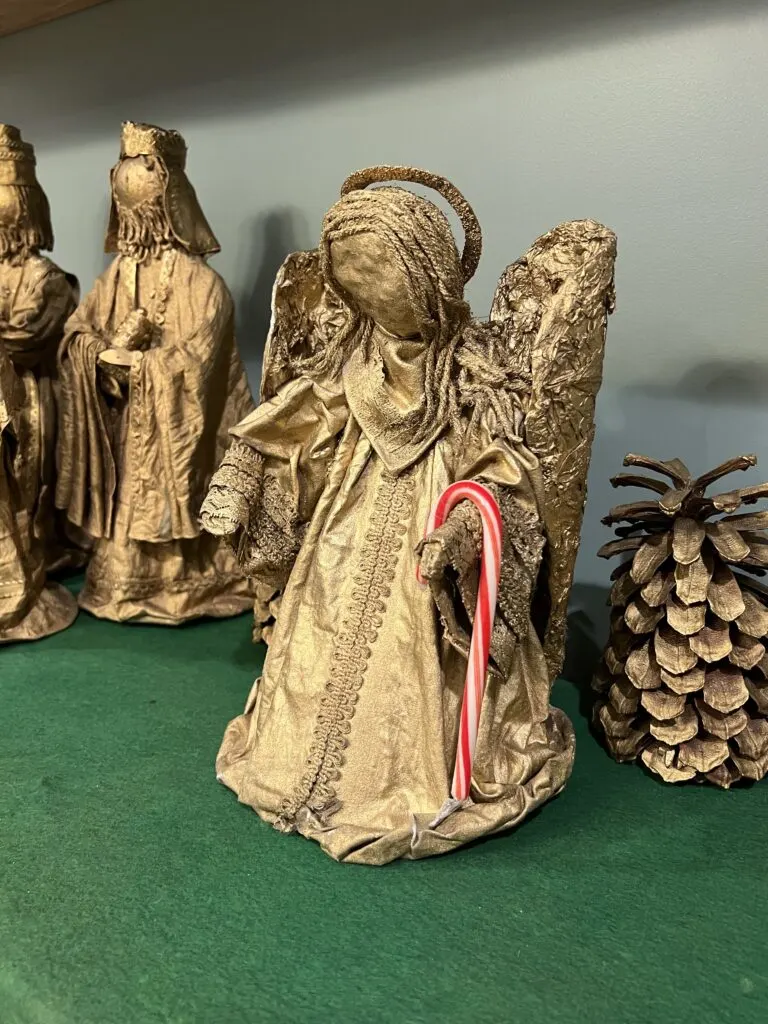 candy cane hanging on a nativity angel