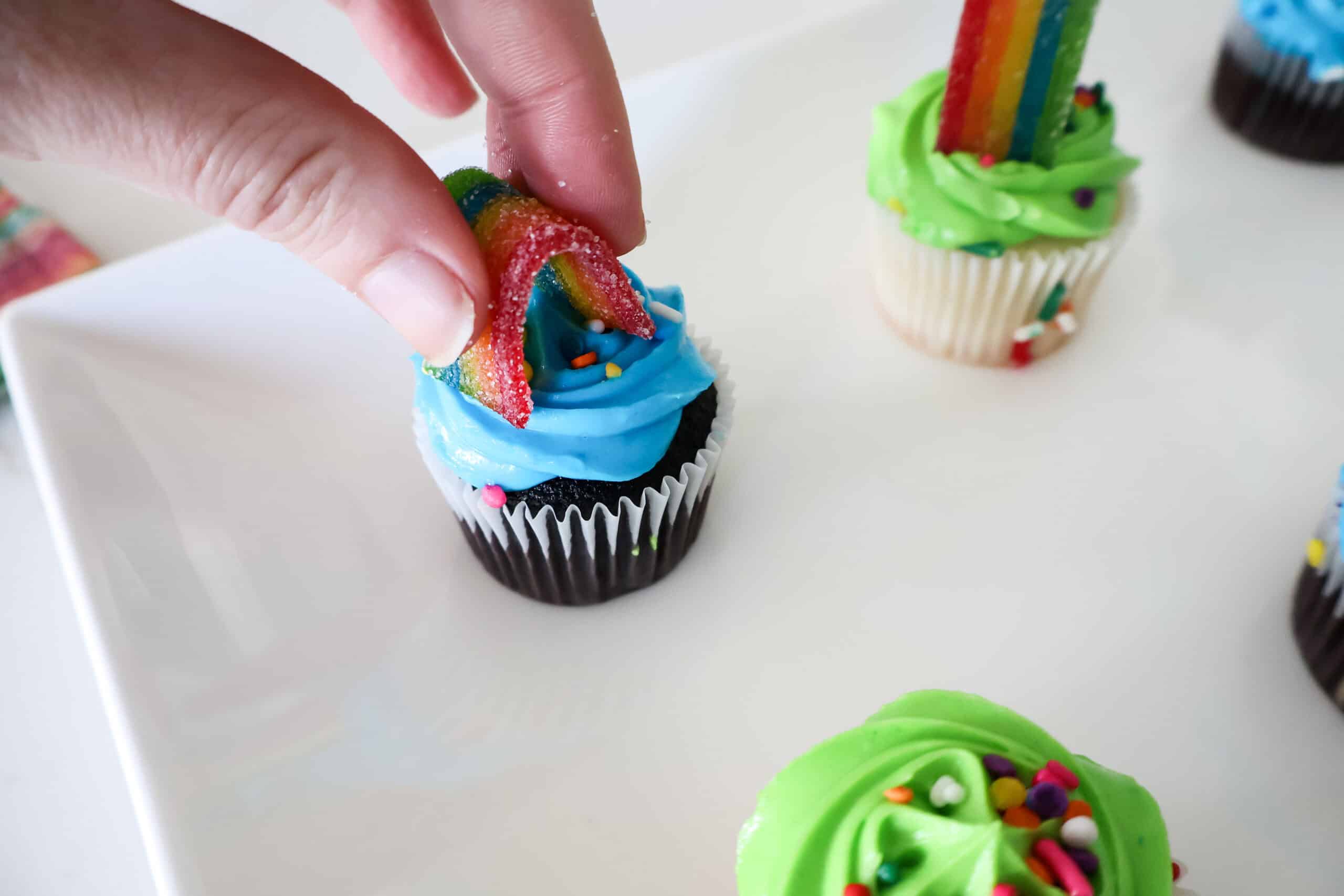 adding gummy rainbows to cupcakes