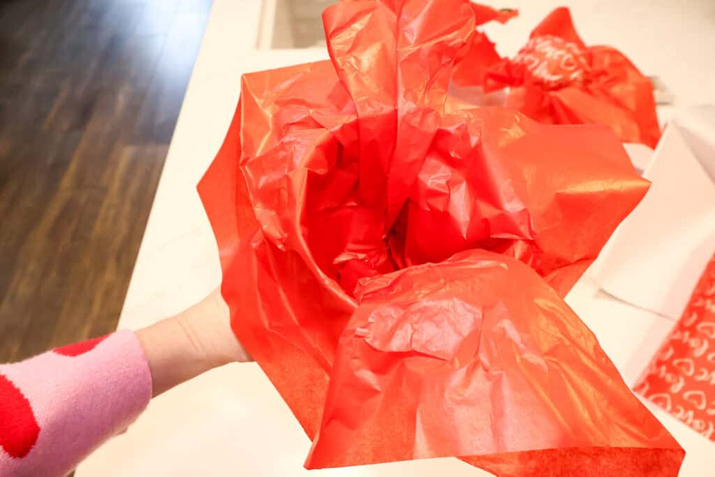 adding tissue paper to a bucket gift