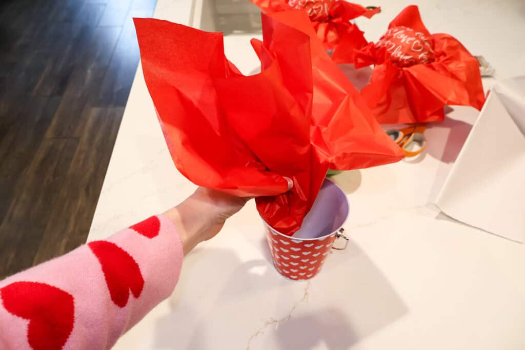 adding tissue paper to a bucket gift