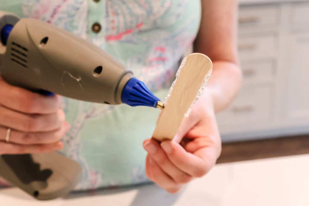 hot gluing popsicle sticks to make popsicles