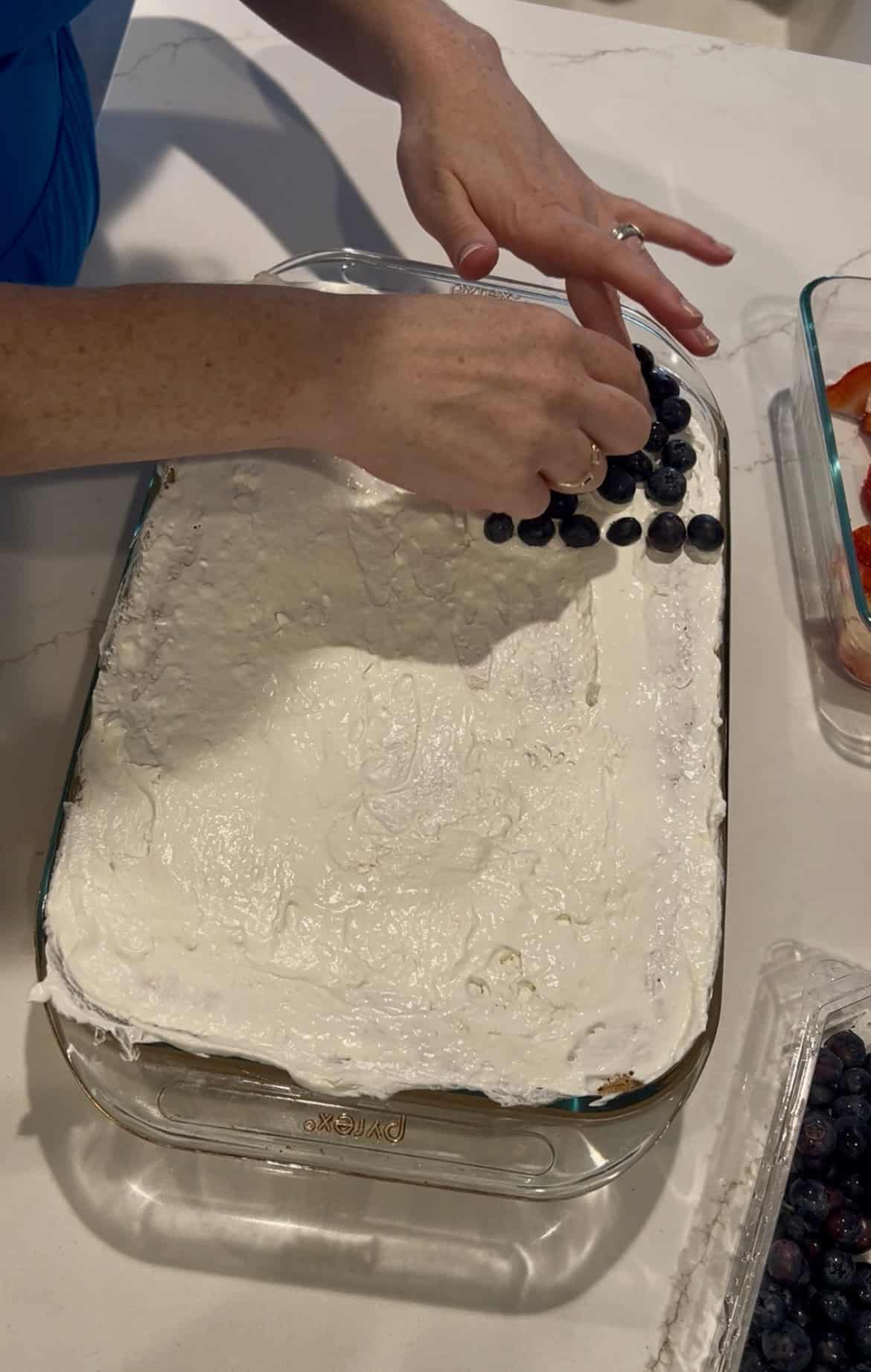 adding blueberries to a cake