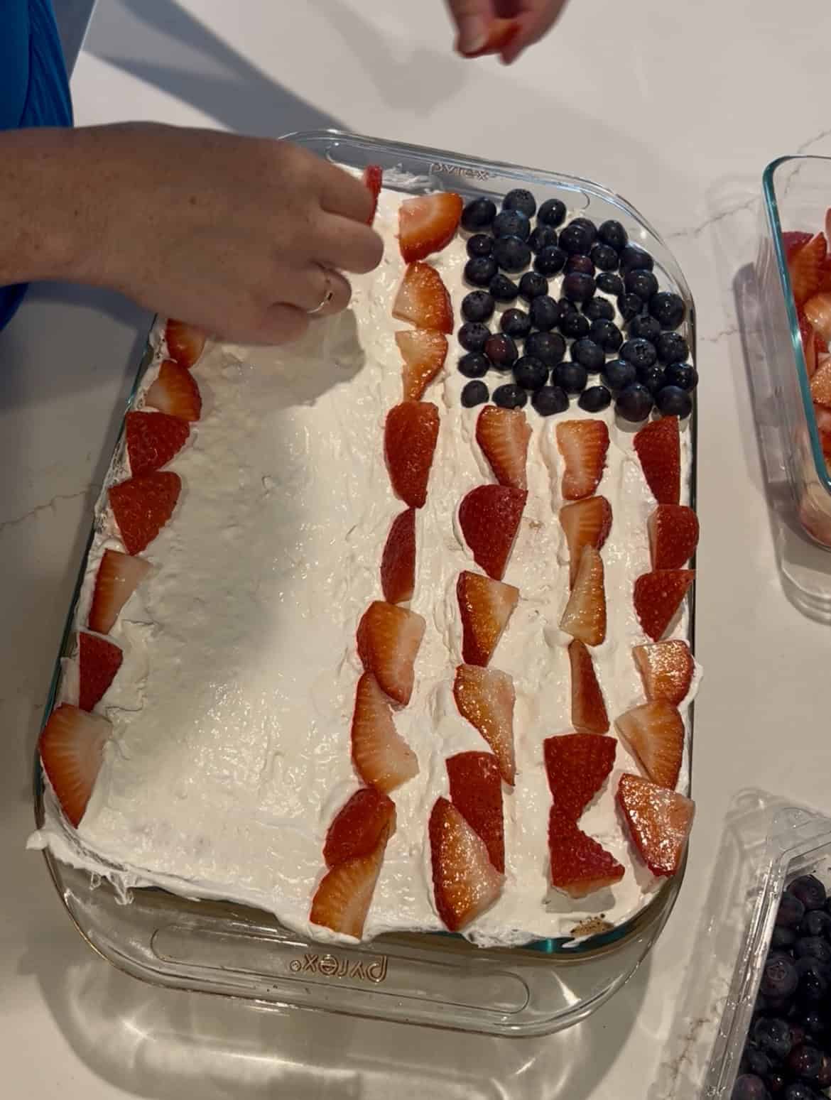 adding strawberries to a cake