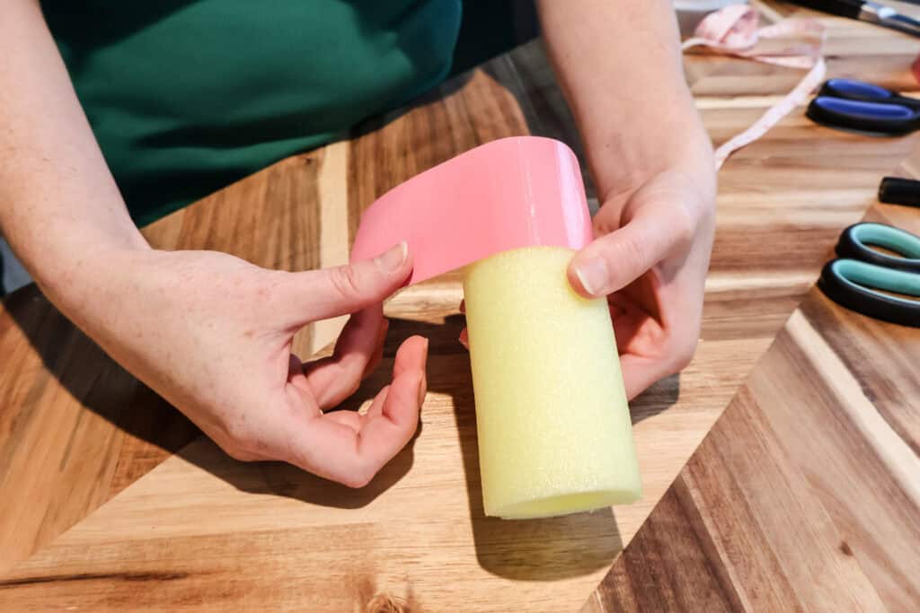 adding pink tape to a pool noodle