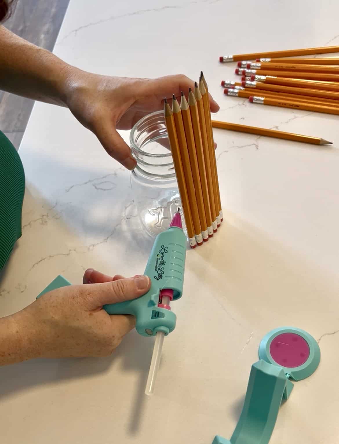 hot gluing pencils to a jar