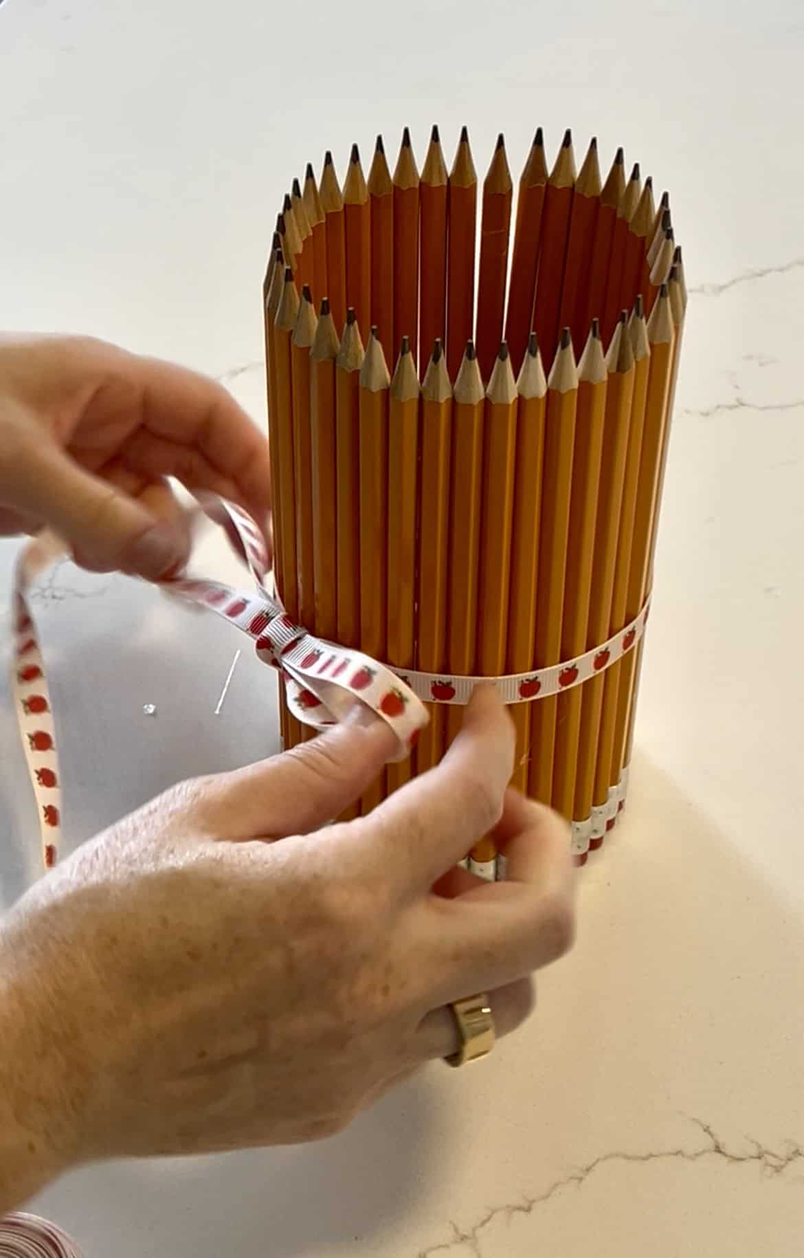 tying a ribbon around a pencil vase