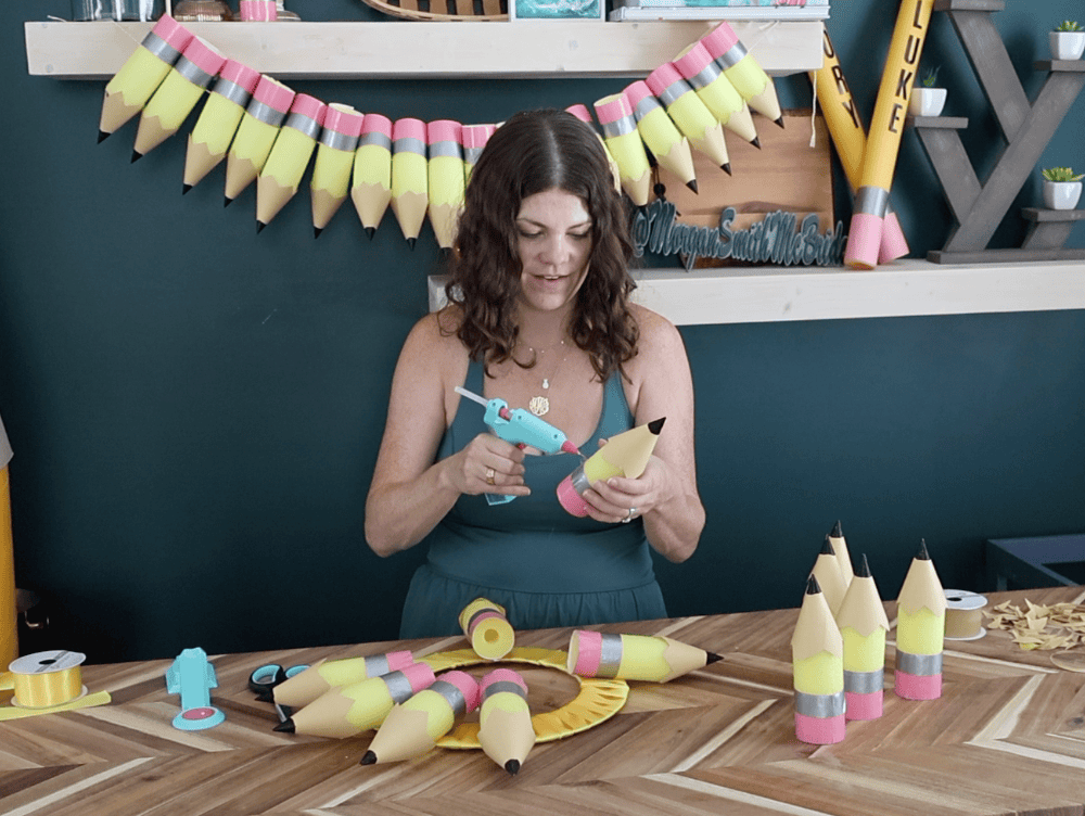 hot gluing pool noodle pencils to a wreath