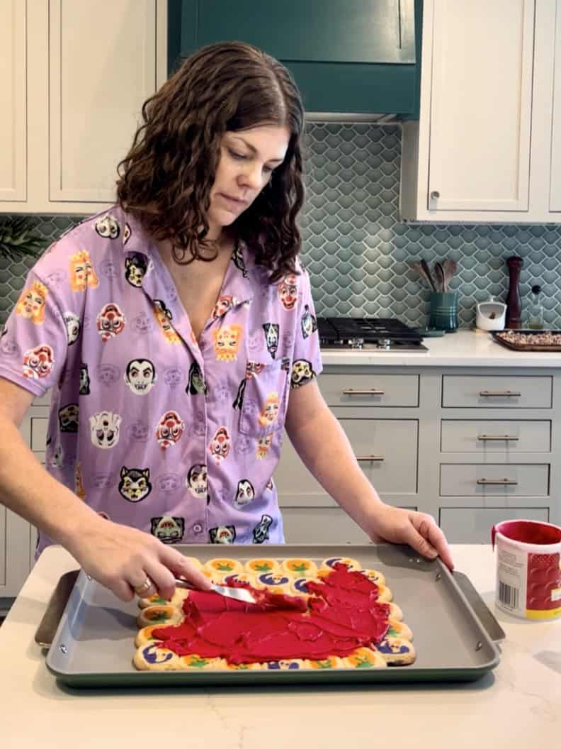 frosting a halloween cookie pizza
