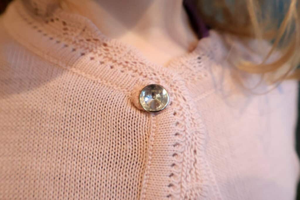 close up of gem button lilax kids girls sweater