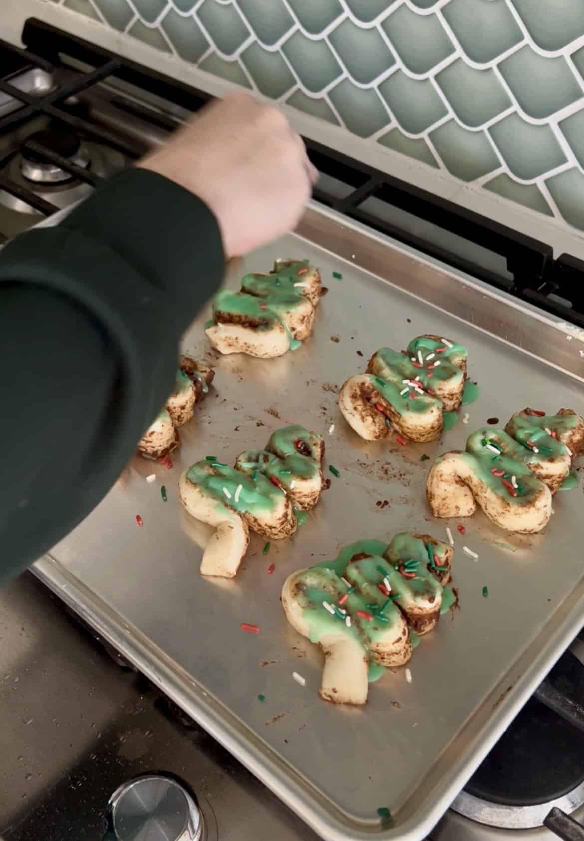 adding sprinkles to christmas cinnamon rolls