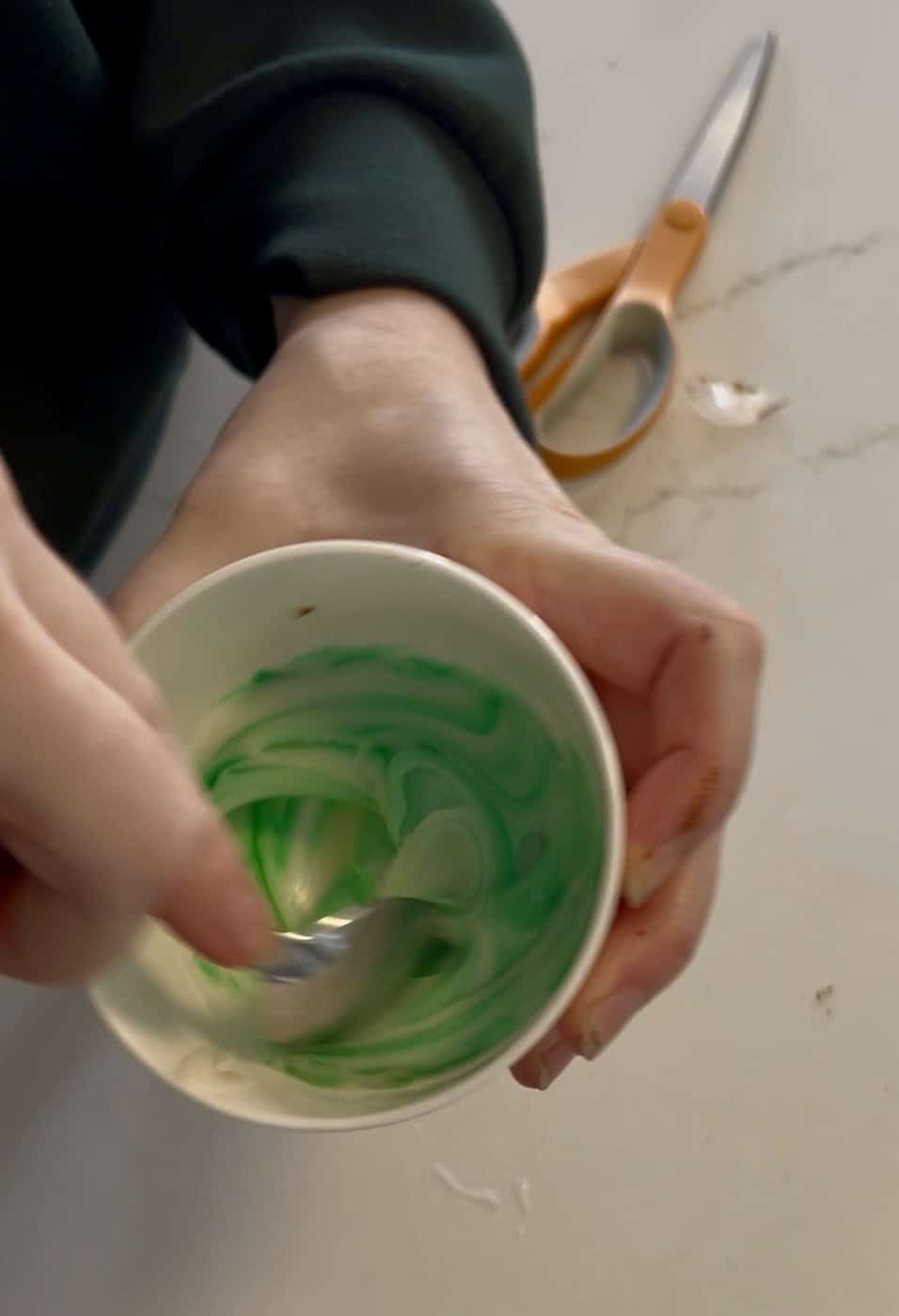 mixing green dye into icing