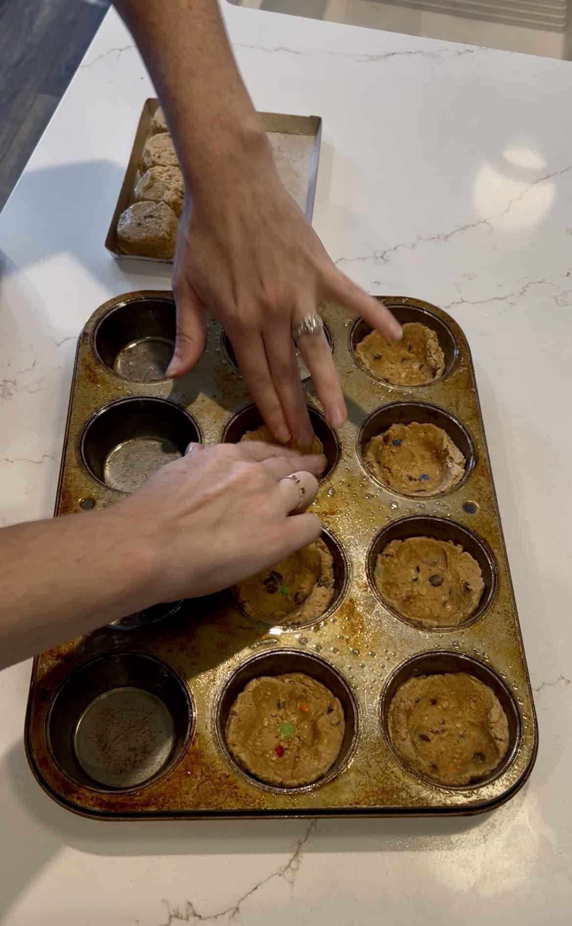 pressing cookies into muffin tin