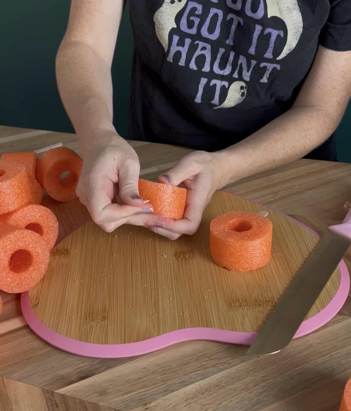 sticking popsicle stick into a pool noodle